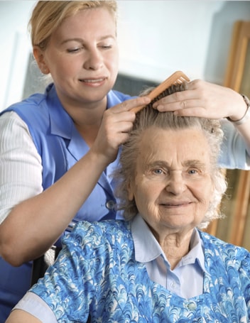 An IRT carer brushing an elderly woman's hair