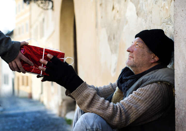 older homeless person receiving a gift