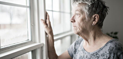 Older woman looking out window